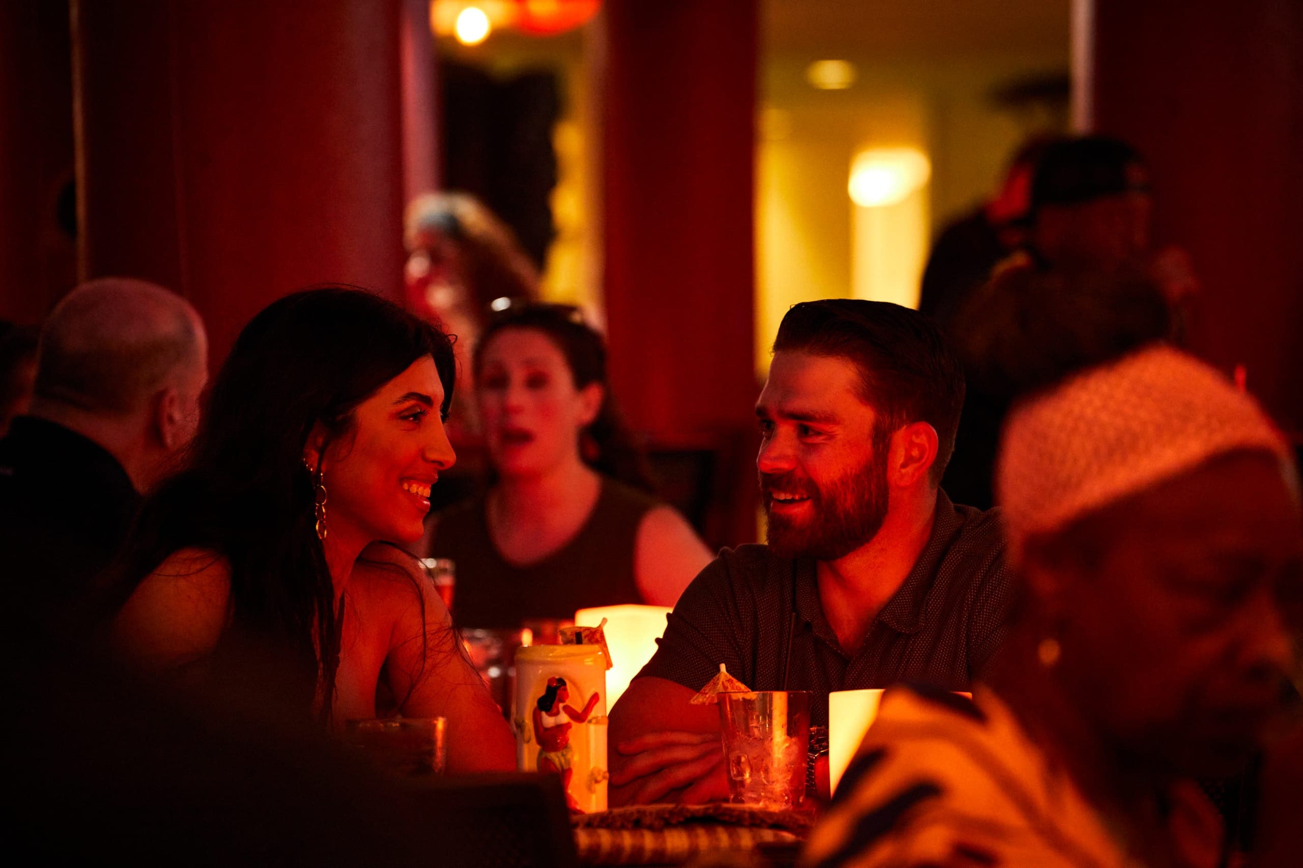 A romantic photo of a couple celebrating their anniversary with a special dinner at Tiki's Grill & Bar, with a focus on their joyful interaction.