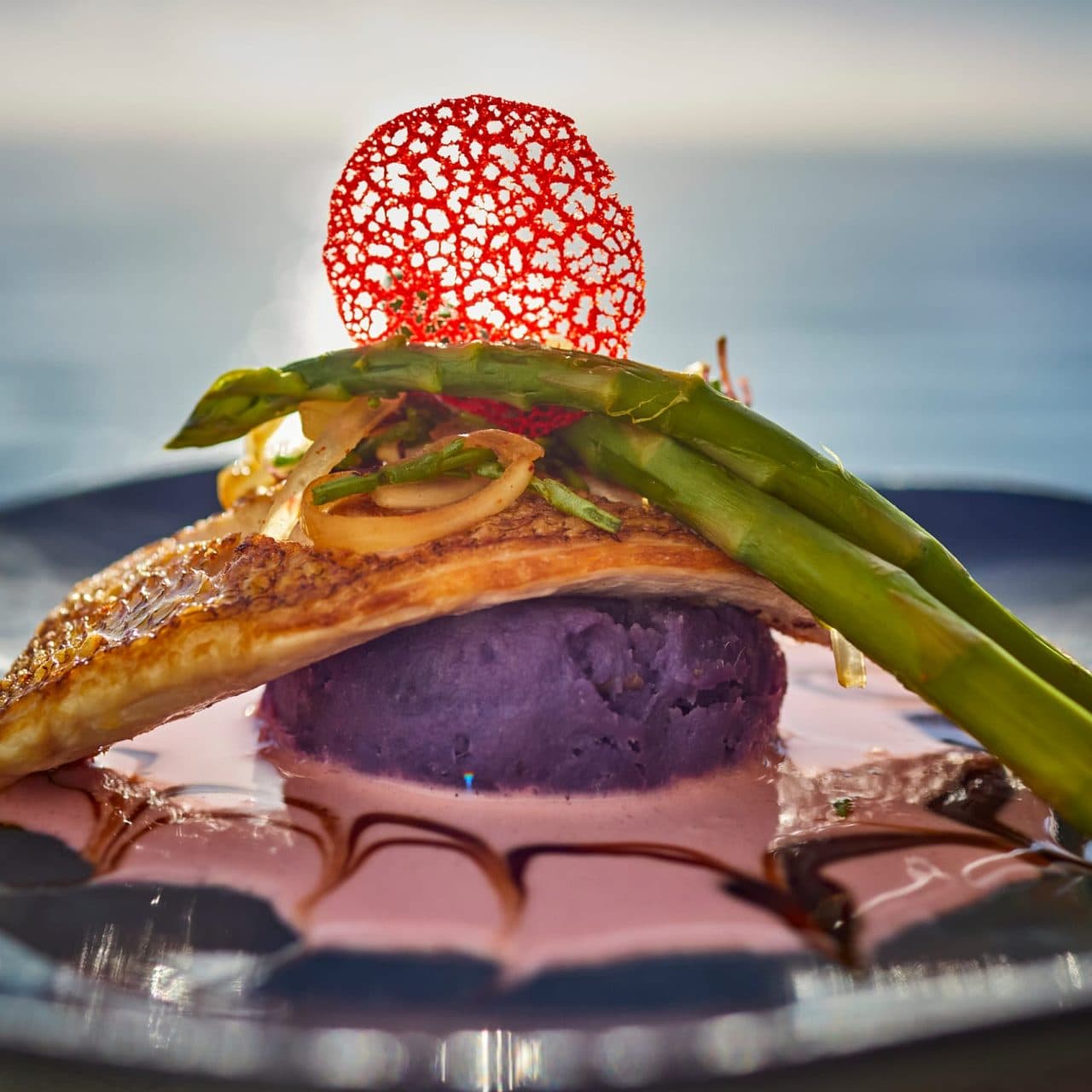 Tiki's Grill & Bar's Teppanyaki Pacific Pink Snapper with Moloka'i potatoes and sea asparagus poke, showcasing fresh, locally sourced Hawaiian cuisine.