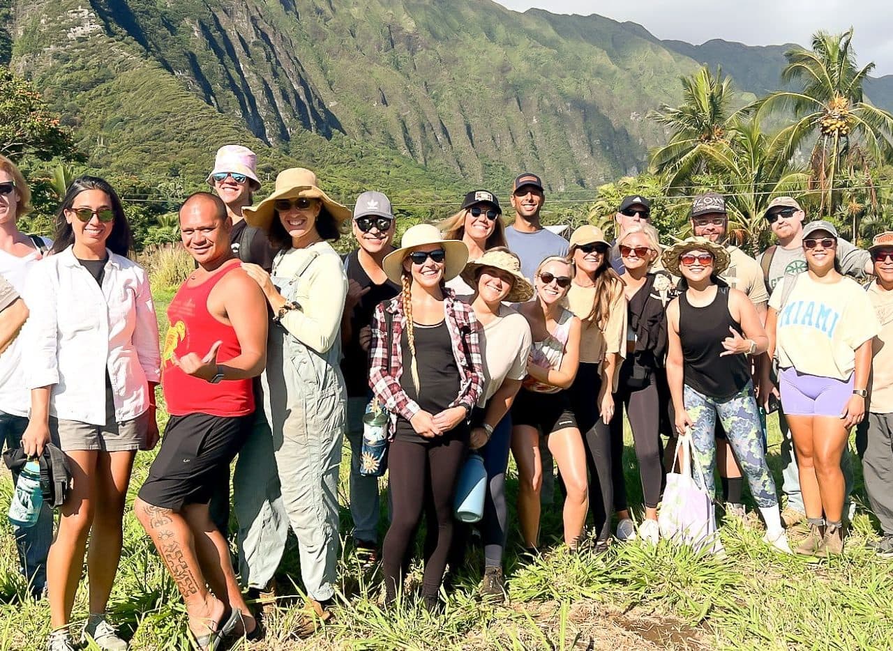 A group of Tiki's Grill & Bar volunteers working to clear a farm plot at Go Farm Hawaii in support of Aloha Harvest.