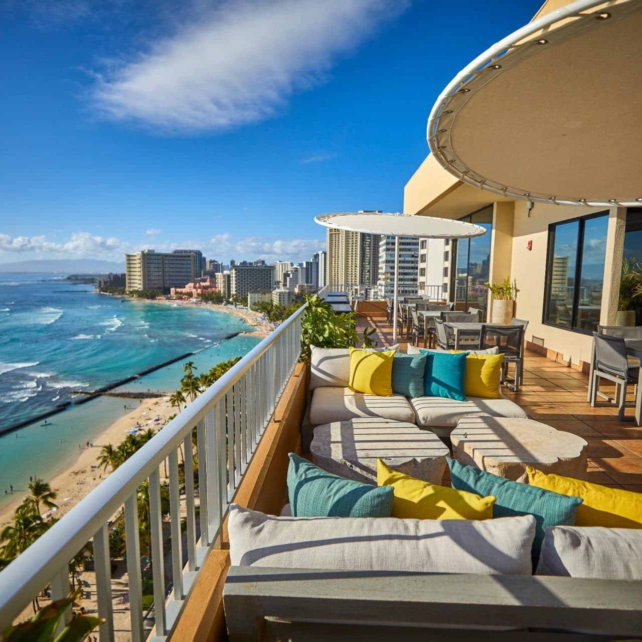 The Coconut Club set up for a casual lounging and cocktail party, with a view of Waikiki's famous surf breaks and the sand below.