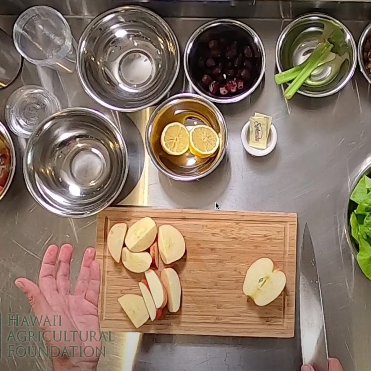 Chef Ronnie from Tiki's Grill & Bar teaching a group of young cooks how to prepare a healthy Waldorf Rainbow Salad with local ingredients.