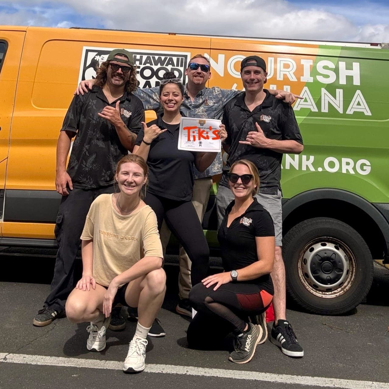Tiki's Grill & Bar team members volunteering at the Hawai'i Food Bank, assembling meals for elderly residents and embodying the aloha spirit.