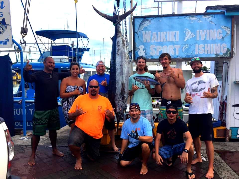 Chef Jason with Tiki’s Grill & Bar managers, chefs, cooks, servers, and bartenders on a Waikiki fishing trip, posing with freshly caught marlin and tuna for Zach’s birthday.